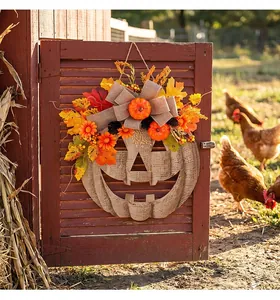 Detail of autumn wooden pumpkin door hanger with fall leaves and burlap bow decor