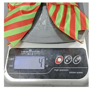 Close-up of a Christmas red and green striped ribbon bow weighing 4 grams on a kitchen scale.
