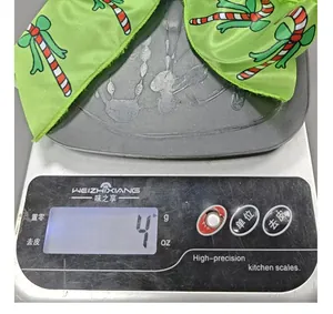 Detailed shot showing the lightweight 4g measurement of a green Christmas bow accessory.