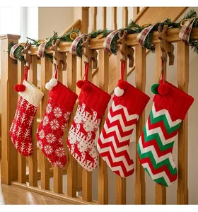 Set of five assorted knit Christmas stockings hanging on a wooden staircase railing