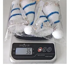 Gedetailleerde gewichtsmeting van witte pailletten kerstmuts ornamenten op een digitale weegschaal.