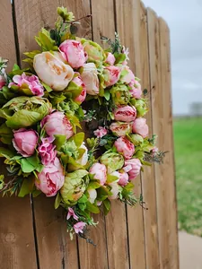 Detailseitenansicht eines Frühlings-Pfingstrosenkranzes mit leuchtend rosa-grünen Kunstblumen