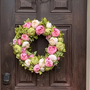Realistischer künstlicher Pfingstrosenkranz mit rosa und cremefarbenen Blüten an der Tür