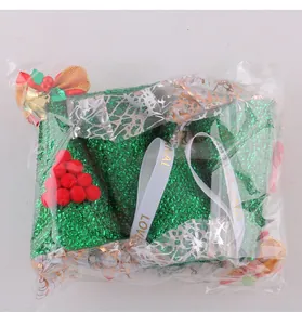 Detailweergave van de groene kerstmuts met pailletten in transparante verpakking