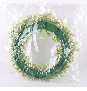 Detail eines Frühlingskranzes mit weißen Blumen in einer klaren Kunststoffverpackung.