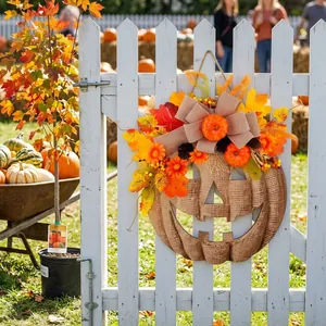 Rustic wooden pumpkin door hanger with autumn leaves and flowers on a white garden fence