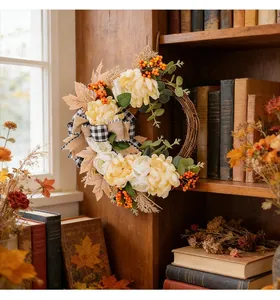 Detail view of autumn floral wreath with yellow flowers and checkered bow on a rustic shelf