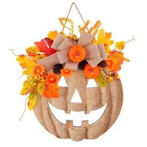 Decorative wooden pumpkin door hanger with autumn leaves and burlap bow for Halloween