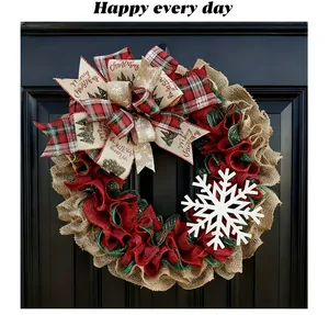 Detail of festive Christmas wreath with burlap mesh, large snowflake and decorative bows.