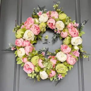 Lebendiger Frühlings-Pfingstrosenkranz mit rosa und weißen Kunstblumen für die Tür.