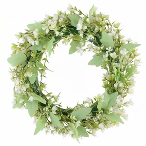 Frühlings-Gartenkranz mit Eukalyptusblättern und kleinen weißen Blüten für die Tür