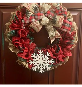 Close-up of burlap Christmas wreath with red mesh and Merry Christmas ribbon bow