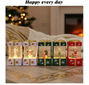 Row of five illuminated Christmas gift box snow globe lanterns on a cozy wooden table