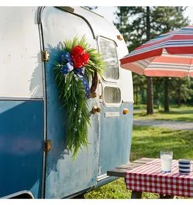 Couronne patriotique de roses rouges du 4 juillet suspendue sur un camping-car bleu vintage