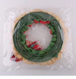 Back view of Christmas burlap wreath in clear plastic packaging showing the green frame