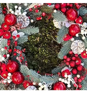 Detailed close-up of a festive Christmas wreath featuring red roses and pine cones