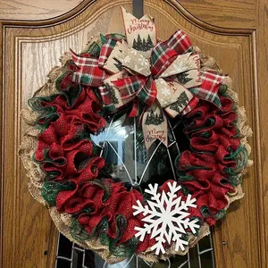 Christmas burlap wreath with red and green ruffles, bow and snowflake on wooden door