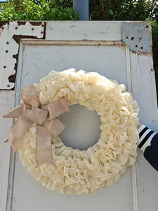 Detail van crème jute krans met een rustieke bruine strik voor feestelijke decoratie