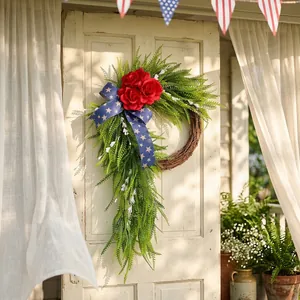 Couronne patriotique du 4 juillet avec roses rouges et ruban bleu sur porte blanche