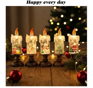 Dettaglio di candele a globo di neve natalizie con figure in miniatura all'interno.
