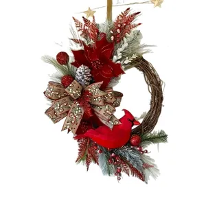 Handgemaakte kerstkrans van wijnranken met een rode kardinaal, kerstster en strik