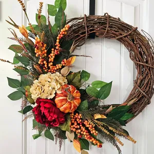 Vue détaillée d'une couronne d'automne avec hortensia rouge et citrouille décorative