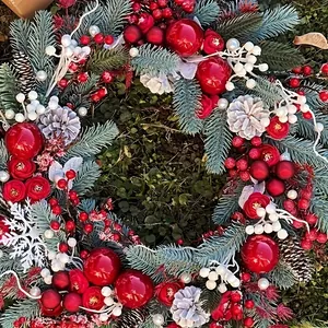 Christmas wreath with blue-green pine needles red roses and festive baubles for door decor
