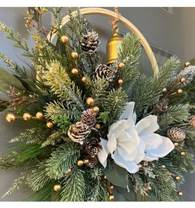 Close-up of a festive Christmas wreath with white magnolia and pine needles.