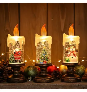Primo piano di tre candele LED natalizie a globo di neve con Babbo Natale e alberello