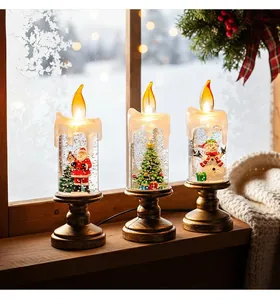 Set di tre candele natalizie con globo di neve con Babbo Natale, albero e pupazzo.