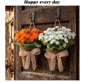 Rustic hanging baskets with white and orange artificial daisies on a wooden door.