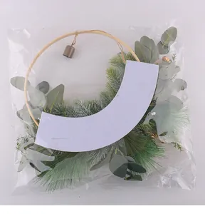 Detailed view of Christmas wreath with pine needles and bell in protective packaging