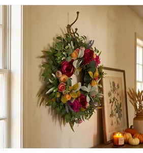 Detailed view of autumn harvest wreath with peonies and mixed leaves on a wall
