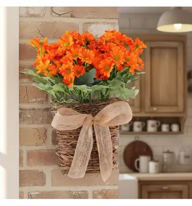 Artificial orange daisy flowers in a woven wall hanging basket for autumn home decor.