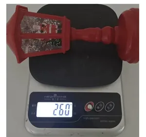 Christmas lantern snow globe weighing approximately 260 grams on a digital scale.
