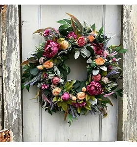 Detailed view of an autumn harvest peony wreath featuring pink flowers on a rustic door