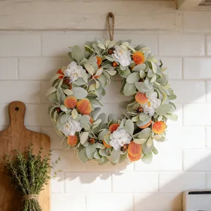 Corona de otoño con hojas de oreja de conejo y flores blancas decorativa