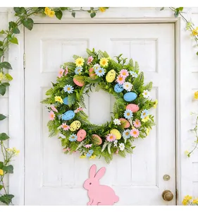 Close-up of a vibrant Easter wreath featuring colorful eggs and flowers on a white door