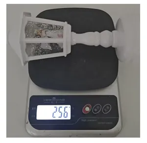 White Christmas lantern snow globe ornament weighing 256g on a digital scale.