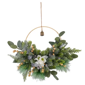 Elegant Christmas wreath decorated with magnolia, pine needles, golden berries and bronze bell