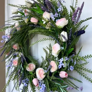 Detailed side view of a spring floral wreath with pink tulips and lavender on a door.