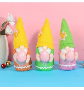 Vue détaillée de trois gnomes de Pâques sans visage tenant des œufs roses à pois