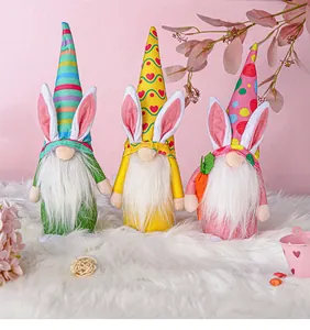 Trois mignons gnomes de Pâques avec des oreilles de lapin sur un tapis blanc moelleux