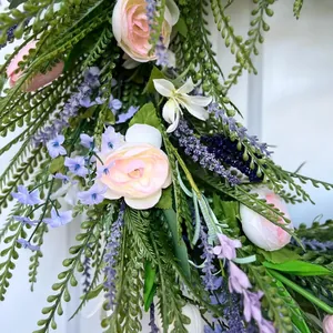 Close-up of spring floral wreath with pink roses, lavender, and lush greenery detail