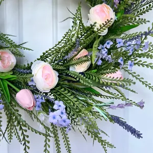 Close-up detail of a vibrant spring floral wreath with pink roses and lavender flowers
