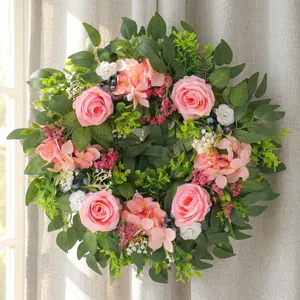 Artificial spring rose wreath with pink flowers and lush green foliage decoration