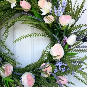 Detailed view of pink roses and lavender on a lush green spring floral door wreath