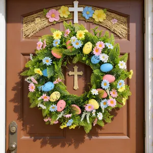 Easter wreath for front door with cross, colorful eggs and spring flowers