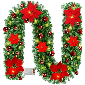 Üppige Weihnachtsgirlande mit roten Poinsettien, Glanzkugeln und warmen LED-Lichtern