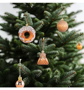 Primo piano di decorazioni natalizie in rame appese a un verde albero di Natale